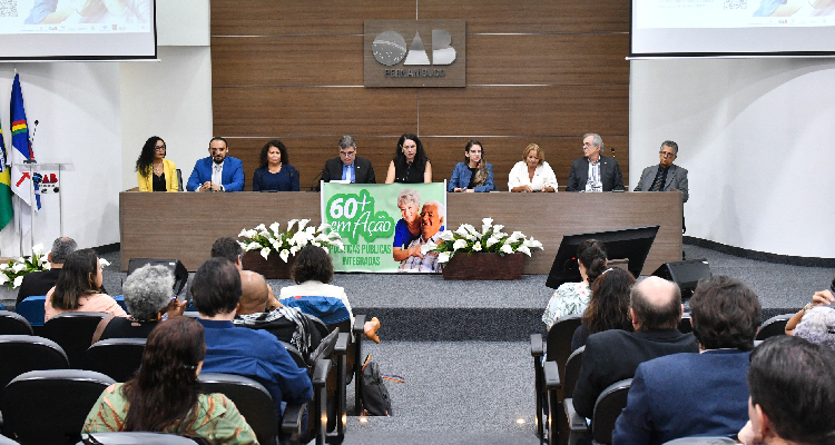 Fotografia de pessoas sentadas diante de mesa com pessoas
